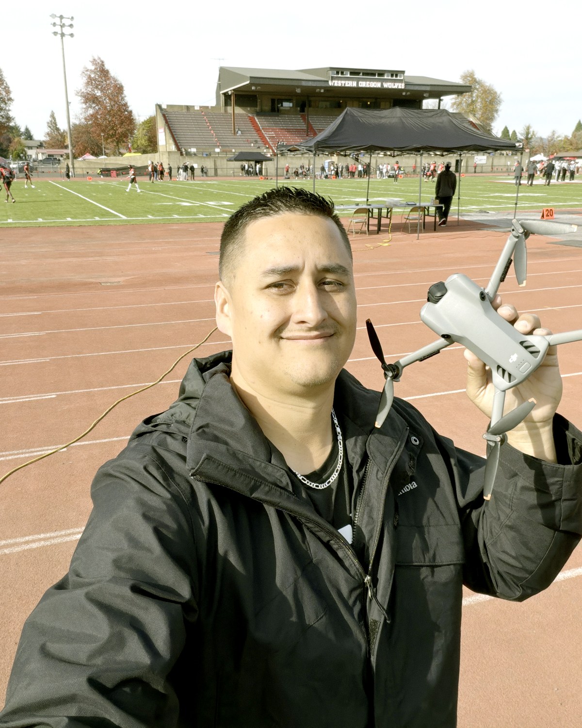 Garrett Lanz holding his drone on a stadium track