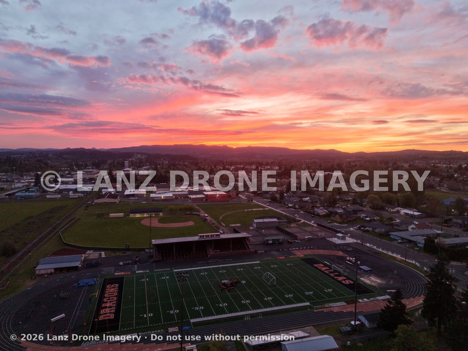 Aerial view of the Dallas Dragons stadium and town under a pink and orange sunset